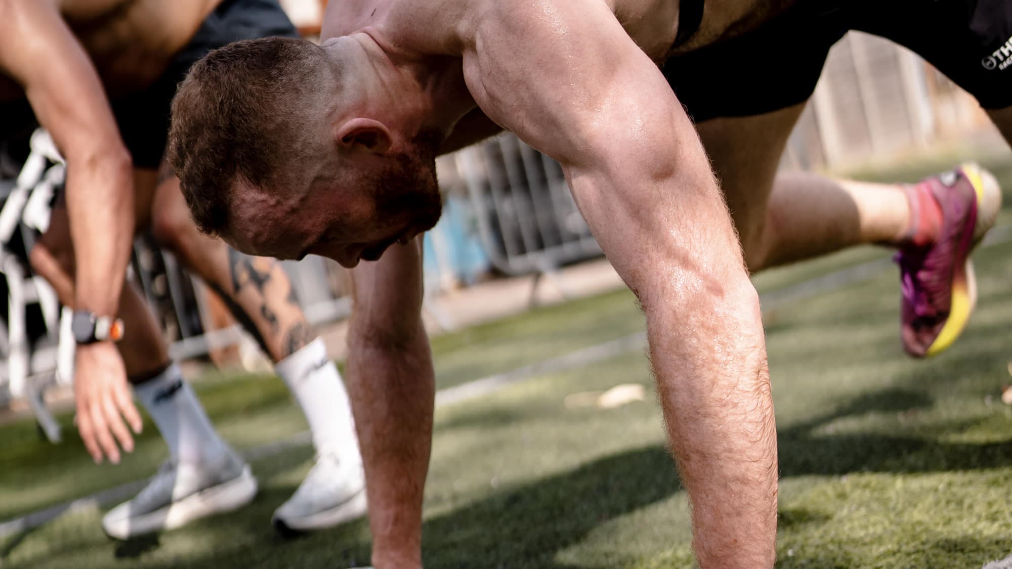 Hands down on the turf at the start of a burpee broad jump