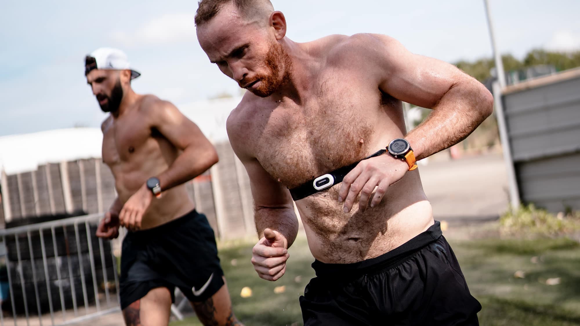 Two athletes running on turf in daylight