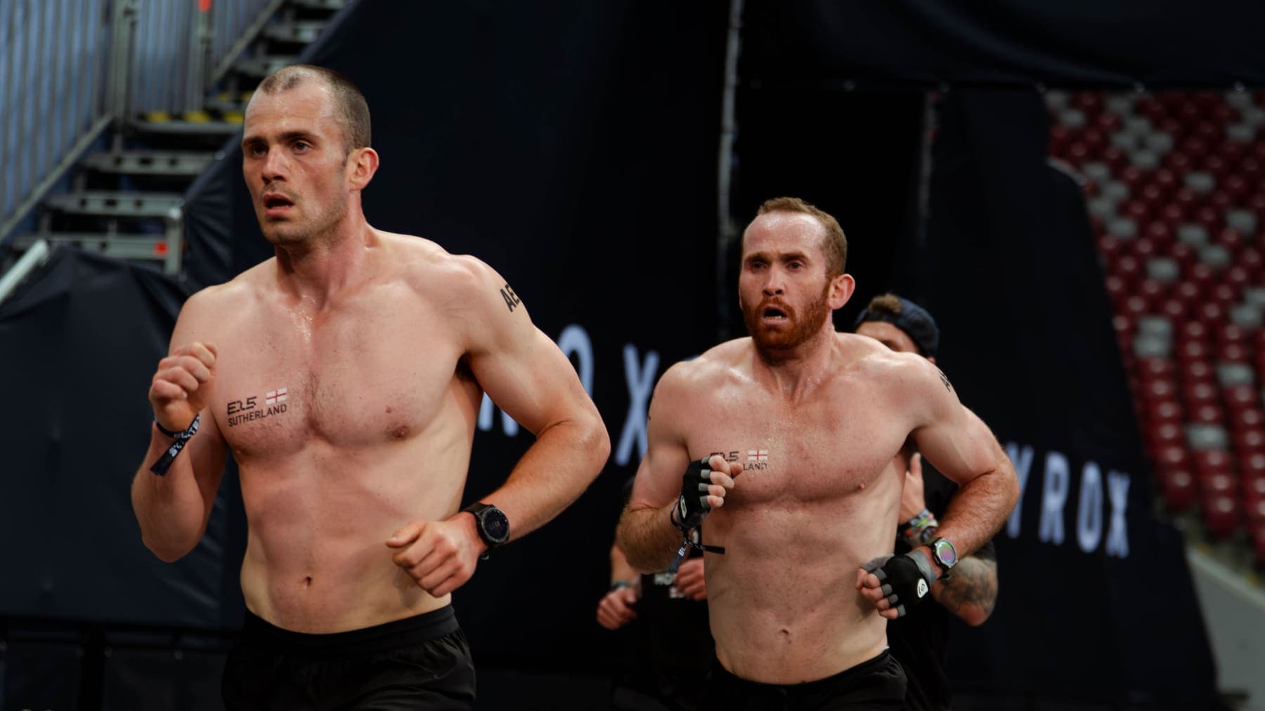 Two athletes running the lap side by side
