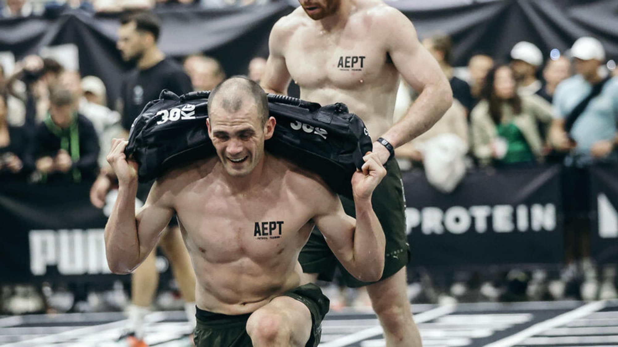 Athlete lunging under a sandbag racked across the shoulders