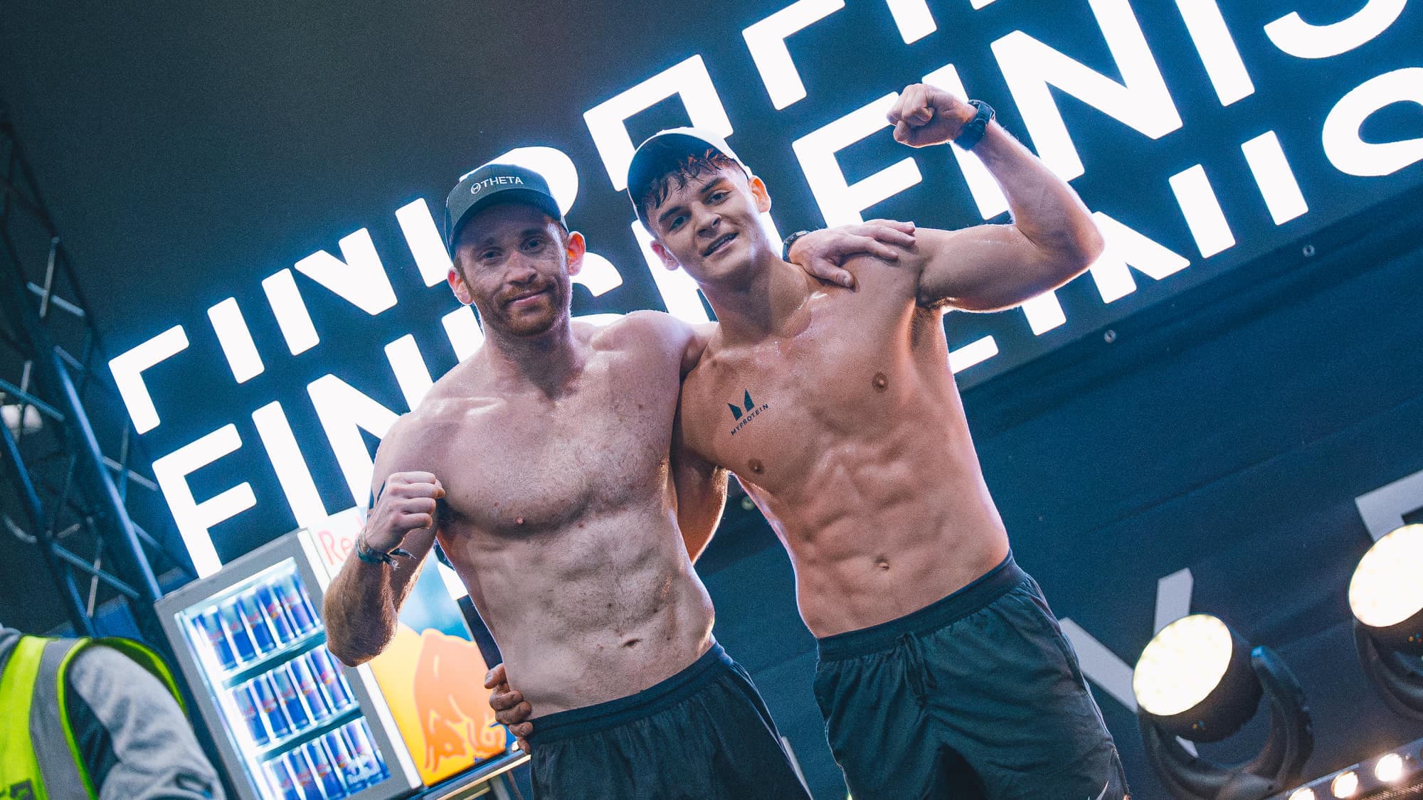 Two athletes celebrating under the finish gantry