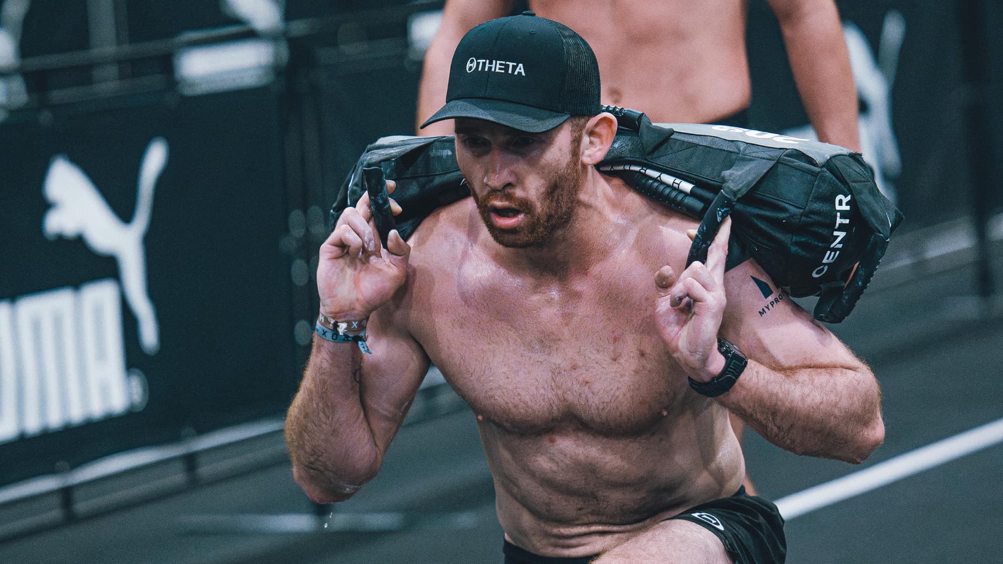 Ben Sutherland lunging under a loaded sandbag at a race