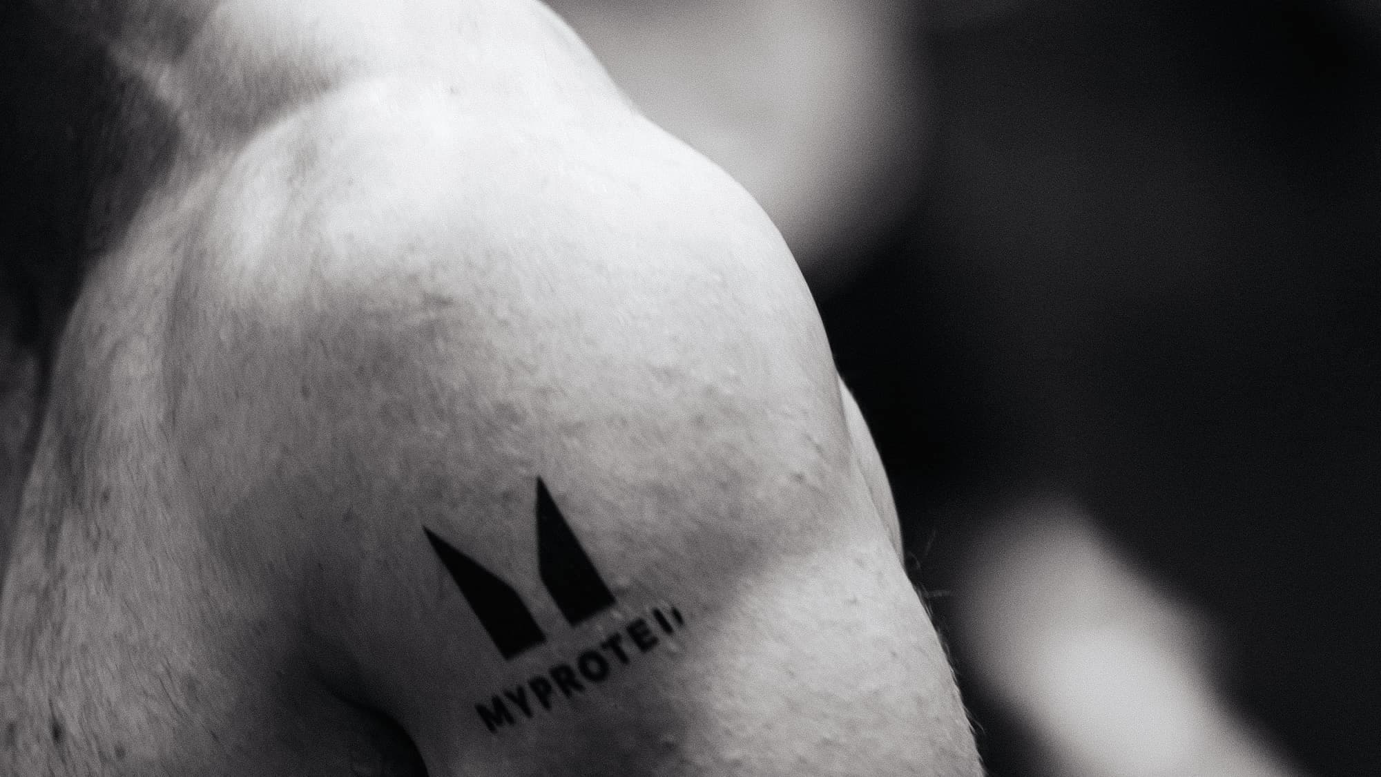 Close black and white detail of an athlete's shoulder at a race