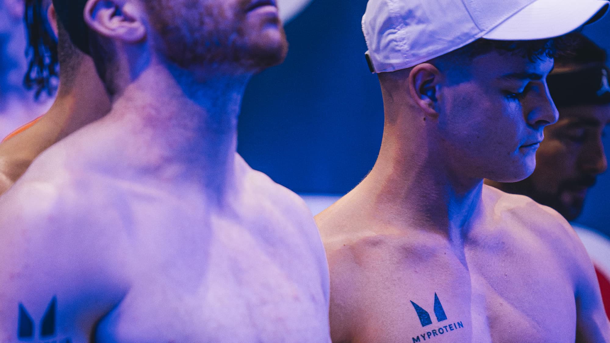 Two athletes in the start pen under the arena lighting