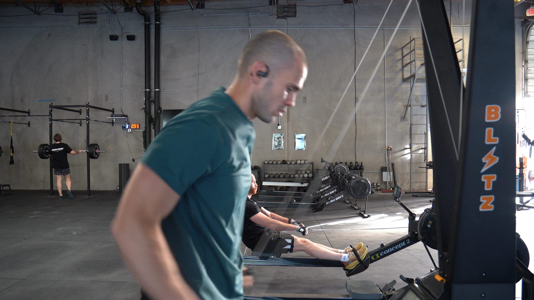 An athlete mid-pull on a ski ergometer in a gym