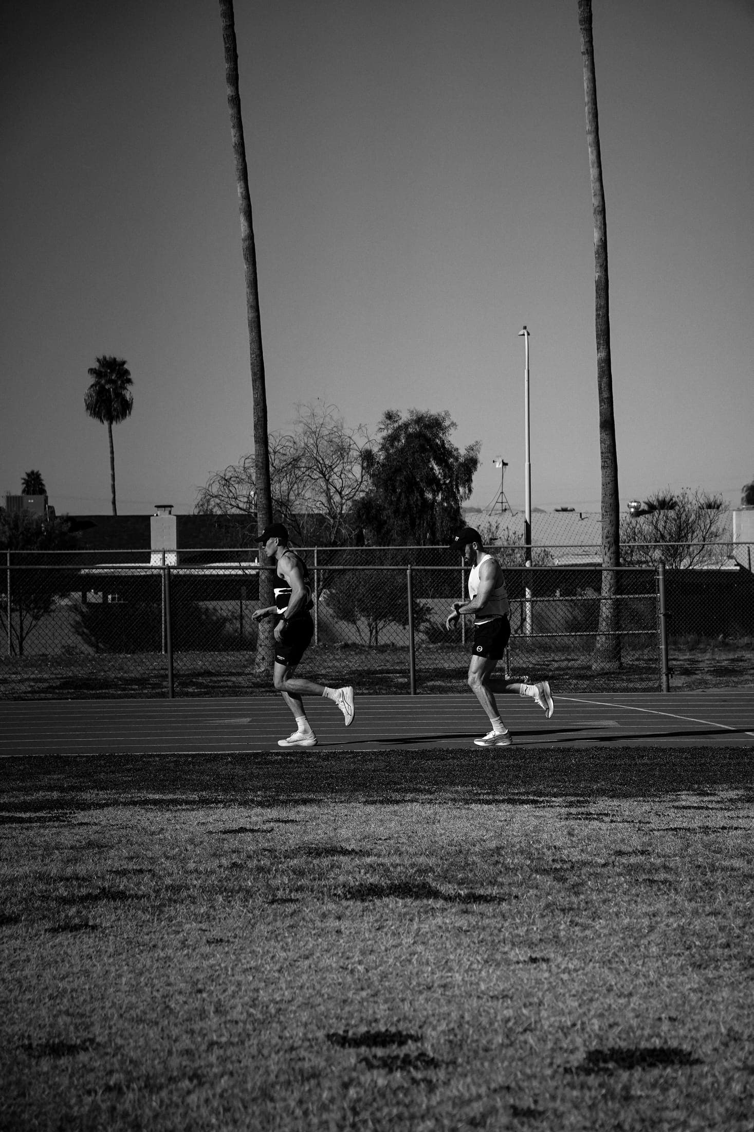 Two athletes running at dusk during a training session